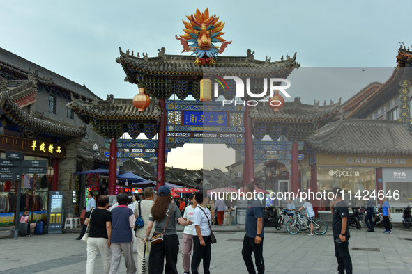 Tourists are enjoying the scenery of Saishang Old Street, the core area of the Saishang Old Street tourism and leisure district, in Hohhot,...