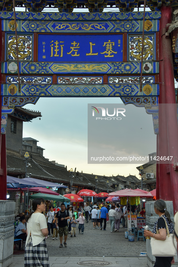 Tourists are enjoying the scenery of Saishang Old Street, the core area of the Saishang Old Street tourism and leisure district, in Hohhot,...