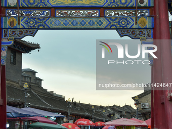 Tourists are enjoying the scenery of Saishang Old Street, the core area of the Saishang Old Street tourism and leisure district, in Hohhot,...