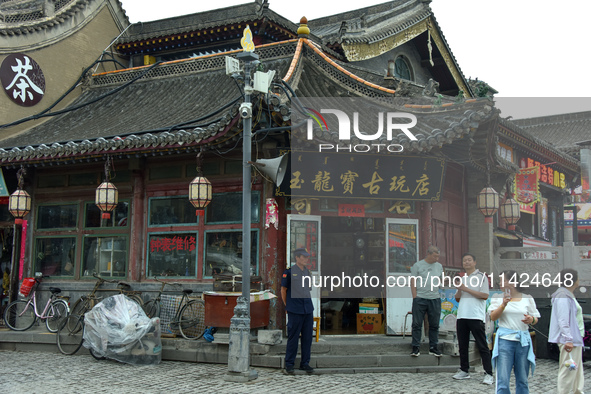 Tourists are enjoying the scenery of Saishang Old Street, the core area of the Saishang Old Street tourism and leisure district, in Hohhot,...