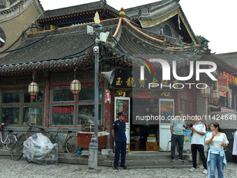 Tourists are enjoying the scenery of Saishang Old Street, the core area of the Saishang Old Street tourism and leisure district, in Hohhot,...