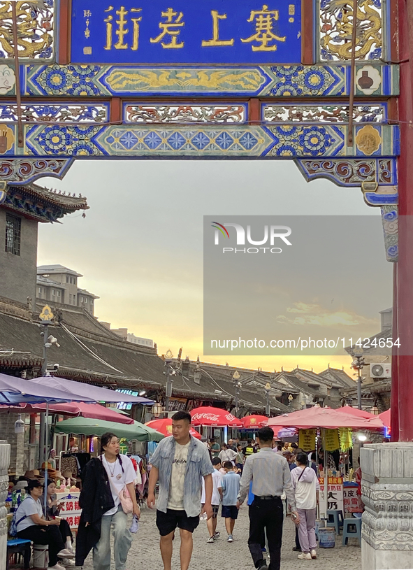 Tourists are enjoying the scenery of Saishang Old Street, the core area of the Saishang Old Street tourism and leisure district, in Hohhot,...