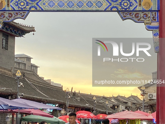 Tourists are enjoying the scenery of Saishang Old Street, the core area of the Saishang Old Street tourism and leisure district, in Hohhot,...