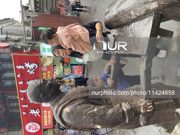 Tourists are enjoying the scenery of Saishang Old Street, the core area of the Saishang Old Street tourism and leisure district, in Hohhot,...