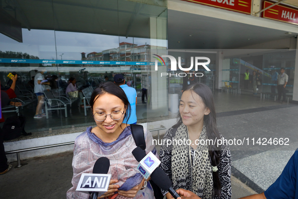 Sadikshya Basent (L), a Nepali student who is returning from violence-hit Bangladesh, is speaking to the media upon arriving at Tribhuvan In...