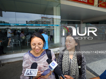 Sadikshya Basent (L), a Nepali student who is returning from violence-hit Bangladesh, is speaking to the media upon arriving at Tribhuvan In...