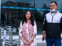 Krishpa Rai (L), a Nepali student who is arriving back from violence-hit Bangladesh, is standing alongside her father after arriving at Trib...