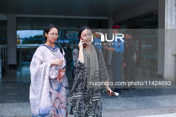 Nepali students Mahima (R) and Sadikshya Basnet (L) are talking over the phone with their family members upon arriving back in Kathmandu, Ne...