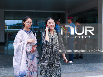 Nepali students Mahima (R) and Sadikshya Basnet (L) are talking over the phone with their family members upon arriving back in Kathmandu, Ne...