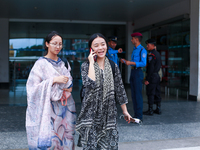 Nepali students Mahima (R) and Sadikshya Basnet (L) are talking over the phone with their family members upon arriving back in Kathmandu, Ne...