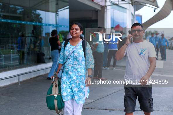 A Nepali student who is arriving back from violence-hit Bangladesh is walking alongside her father towards the vehicle after arriving at Tri...