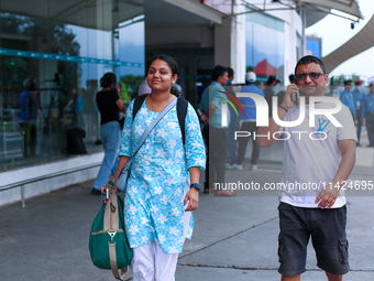 A Nepali student who is arriving back from violence-hit Bangladesh is walking alongside her father towards the vehicle after arriving at Tri...