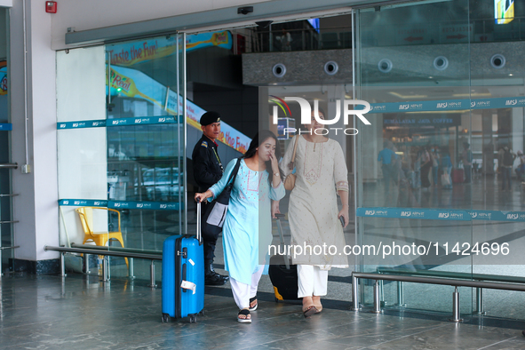 Nepali students are exiting the terminal of Tribhuvan International Airport upon arriving back in Kathmandu, Nepal, from violence-hit Bangla...