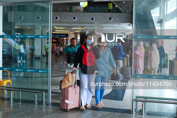 Nepali students are exiting the terminal of Tribhuvan International Airport upon arriving back in Kathmandu, Nepal, from violence-hit Bangla...