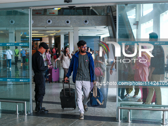 Nepali students are exiting the terminal of Tribhuvan International Airport upon arriving back in Kathmandu, Nepal, from violence-hit Bangla...