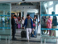 Nepali students are exiting the terminal of Tribhuvan International Airport upon arriving back in Kathmandu, Nepal, from violence-hit Bangla...