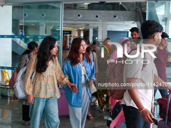 Nepali students are exiting the terminal of Tribhuvan International Airport upon arriving back in Kathmandu, Nepal, from violence-hit Bangla...