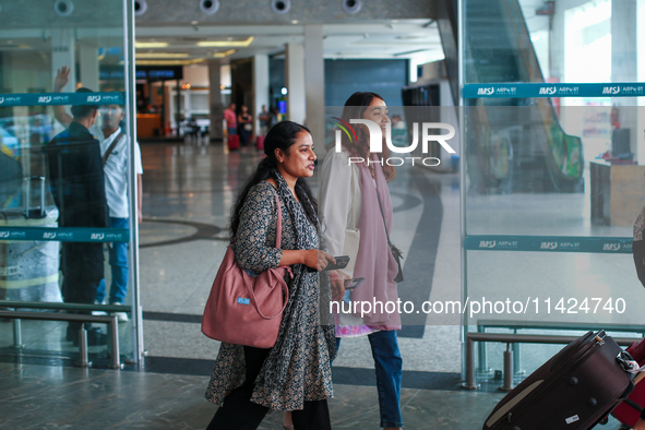 Nepali students are exiting the terminal of Tribhuvan International Airport upon arriving back in Kathmandu, Nepal, from violence-hit Bangla...