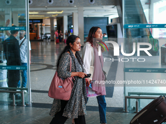 Nepali students are exiting the terminal of Tribhuvan International Airport upon arriving back in Kathmandu, Nepal, from violence-hit Bangla...