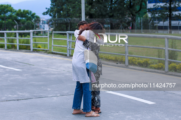 A Nepali student who is returning to Nepal from violence-hit Bangladesh is hugging her relative upon arrival at Tribhuvan International Airp...