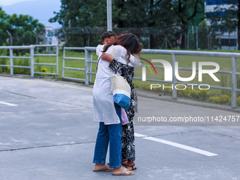 A Nepali student who is returning to Nepal from violence-hit Bangladesh is hugging her relative upon arrival at Tribhuvan International Airp...