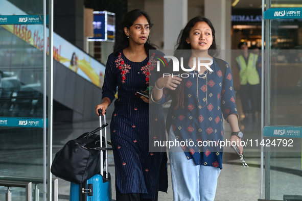 Nepali students are exiting the terminal of Tribhuvan International Airport upon arriving back in Kathmandu, Nepal, from violence-hit Bangla...