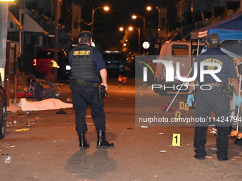 The crime scene unit is at the scene of a mass shooting with evidence markers placed on the ground, in Philadelphia, Pennsylvania, on July 2...