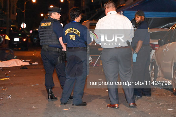 The crime scene unit is at the scene of a mass shooting with evidence markers placed on the ground, in Philadelphia, Pennsylvania, on July 2...