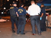 The crime scene unit is at the scene of a mass shooting with evidence markers placed on the ground, in Philadelphia, Pennsylvania, on July 2...