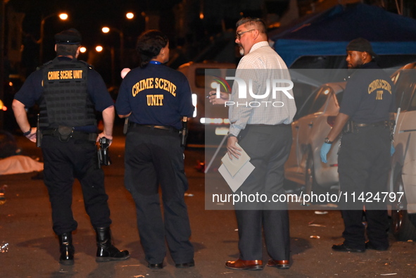 The crime scene unit is at the scene of a mass shooting with evidence markers placed on the ground, in Philadelphia, Pennsylvania, on July 2...