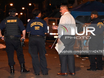 The crime scene unit is at the scene of a mass shooting with evidence markers placed on the ground, in Philadelphia, Pennsylvania, on July 2...