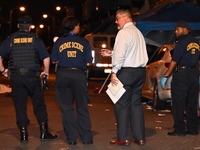 The crime scene unit is at the scene of a mass shooting with evidence markers placed on the ground, in Philadelphia, Pennsylvania, on July 2...