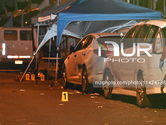 The crime scene unit is at the scene of a mass shooting with evidence markers placed on the ground, in Philadelphia, Pennsylvania, on July 2...