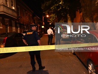 The crime scene unit is at the scene of a mass shooting with evidence markers placed on the ground, in Philadelphia, Pennsylvania, on July 2...