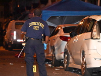 The crime scene unit is at the scene of a mass shooting with evidence markers placed on the ground, in Philadelphia, Pennsylvania, on July 2...