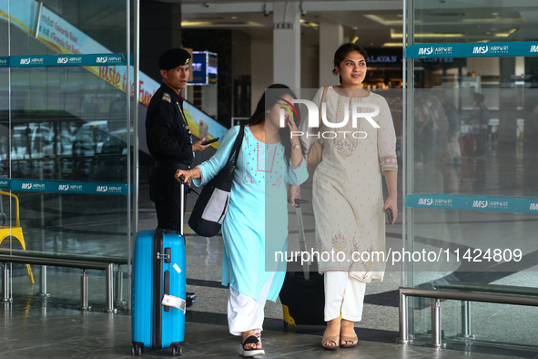 Nepali students are exiting the terminal of Tribhuvan International Airport upon arriving back in Kathmandu, Nepal, from violence-hit Bangla...