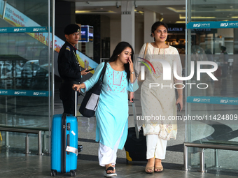 Nepali students are exiting the terminal of Tribhuvan International Airport upon arriving back in Kathmandu, Nepal, from violence-hit Bangla...