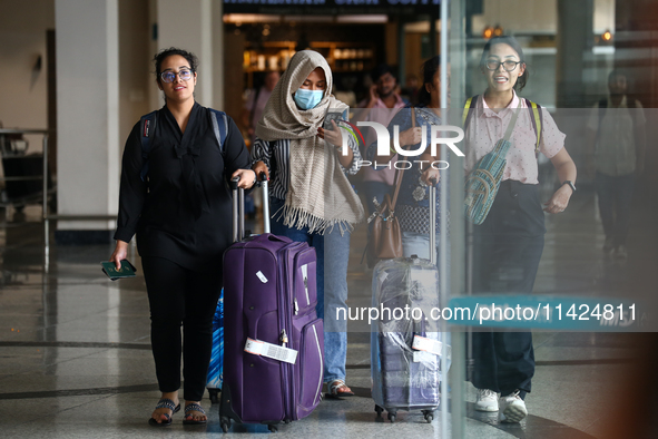 Nepali students are exiting the terminal of Tribhuvan International Airport upon arriving back in Kathmandu, Nepal, from violence-hit Bangla...