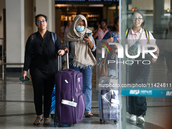 Nepali students are exiting the terminal of Tribhuvan International Airport upon arriving back in Kathmandu, Nepal, from violence-hit Bangla...