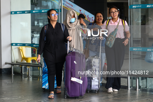 Nepali students are exiting the terminal of Tribhuvan International Airport upon arriving back in Kathmandu, Nepal, from violence-hit Bangla...