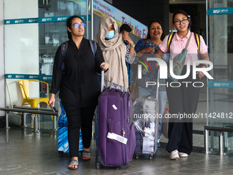 Nepali students are exiting the terminal of Tribhuvan International Airport upon arriving back in Kathmandu, Nepal, from violence-hit Bangla...