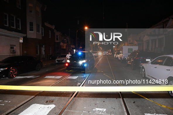 The crime scene unit is at the scene of a mass shooting with evidence markers placed on the ground, in Philadelphia, Pennsylvania, on July 2...