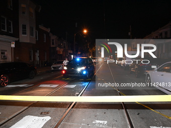 The crime scene unit is at the scene of a mass shooting with evidence markers placed on the ground, in Philadelphia, Pennsylvania, on July 2...