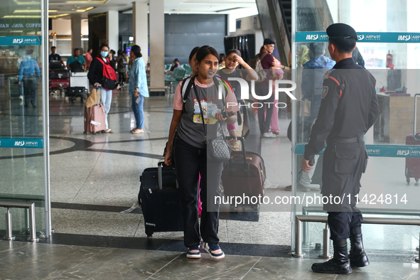 Nepali students are exiting the terminal of Tribhuvan International Airport upon arriving back in Kathmandu, Nepal, from violence-hit Bangla...