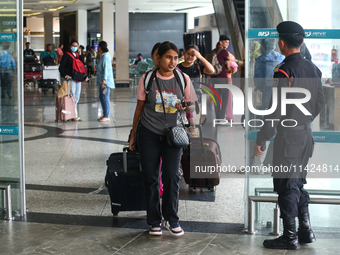 Nepali students are exiting the terminal of Tribhuvan International Airport upon arriving back in Kathmandu, Nepal, from violence-hit Bangla...