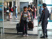 Nepali students are exiting the terminal of Tribhuvan International Airport upon arriving back in Kathmandu, Nepal, from violence-hit Bangla...