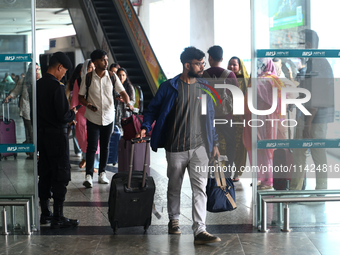 Nepali students are exiting the terminal of Tribhuvan International Airport upon arriving back in Kathmandu, Nepal, from violence-hit Bangla...