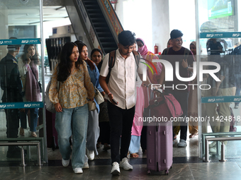 Nepali students are exiting the terminal of Tribhuvan International Airport upon arriving back in Kathmandu, Nepal, from violence-hit Bangla...