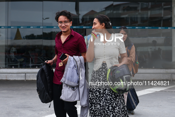 Nepali students are exiting the terminal of Tribhuvan International Airport upon arriving back in Kathmandu, Nepal, from violence-hit Bangla...