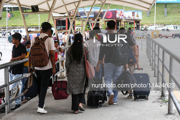 Nepali students are exiting the terminal of Tribhuvan International Airport upon arriving back in Kathmandu, Nepal, from violence-hit Bangla...